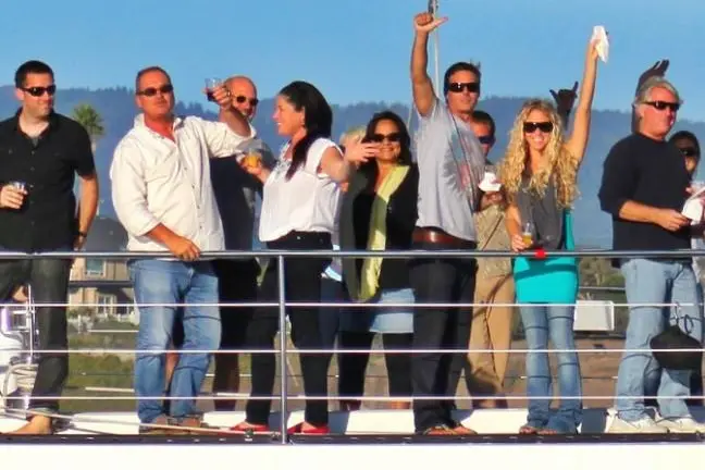 a group of people standing next to a fence